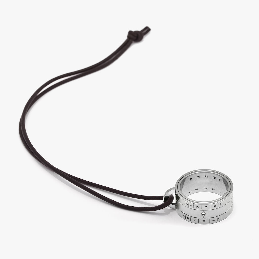 Anneau cadran solaire en acier inoxydable avec découpe au laser des heures et des mois. 19 mm de diamètre. Corde en cuir de chèvre, noire.